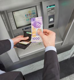 Prelievo di banconote da 1000 franchi dal distributore automatico